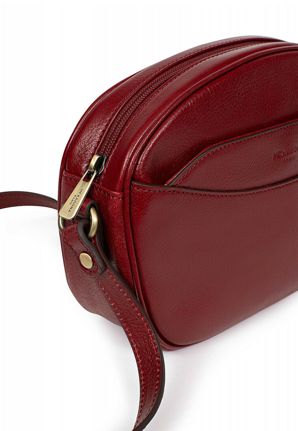 Vue du sac Hexagona en cuir carminé porté à l'épaule, montrant la bandoulière et la boucle